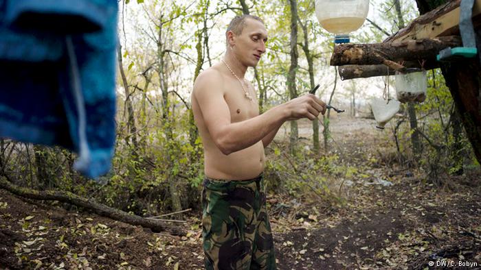 A marine shaves on an autumn morning on the Donetsk front